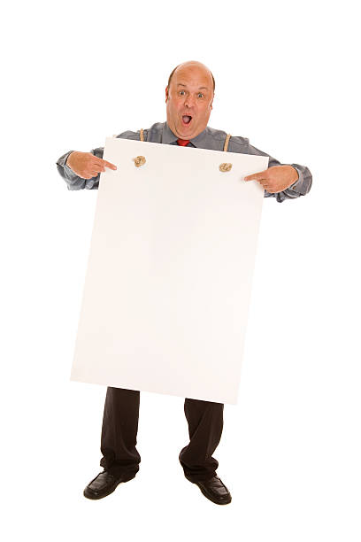 istock Bald man pointing to a blank sign he is wearing 471321789