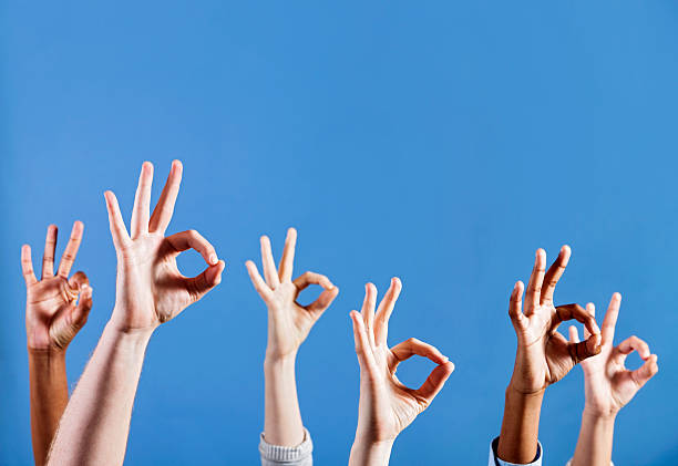 istock Many hands sigalling "OK" against sky blue background 471322237