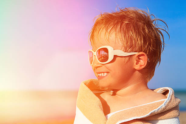 istock happy little boy laugh wrapped in beach towel on sky 471322398