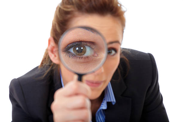 istock Smiling woman holding a magnifying glass over one eye 471324537