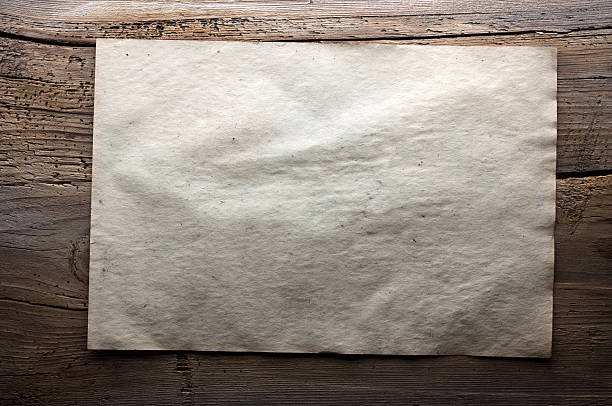 istock paper on wooden background 471325292