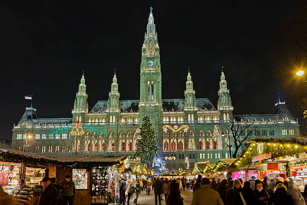Vienna, Austria - December 14, 2010: people at the Christkindlmarkt in the Rathausplatz, the most important Christmas Market among the numerous of the city. In the background stands the imposing Vienna City Hall, a beautiful example of Gothic Revival architecture.