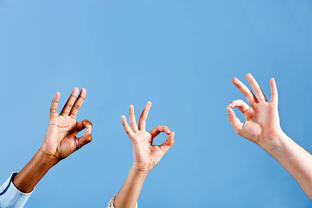 istock Three mixed hands give "OK" sign against sky blue 471326987
