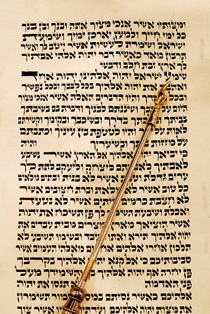 Torah and Yad Pointing to the Shema Torah scroll with with a gold yad pointer, opened to Deuteronomy 6:4, known as the Shema. simchat torah photos stock pictures, royalty-free photos & images