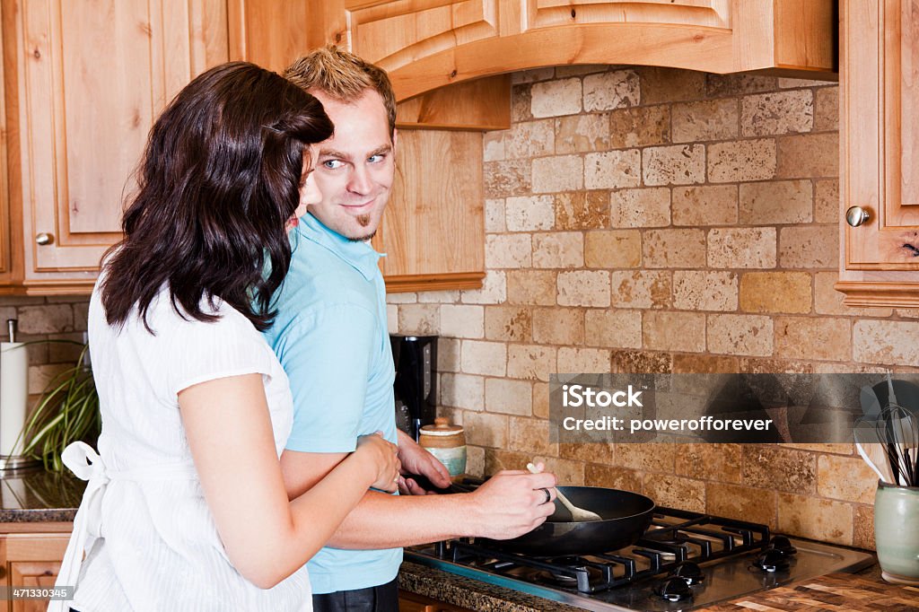 Pareja joven cocinar en la cocina - Foto de stock de Abrazar libre de derechos