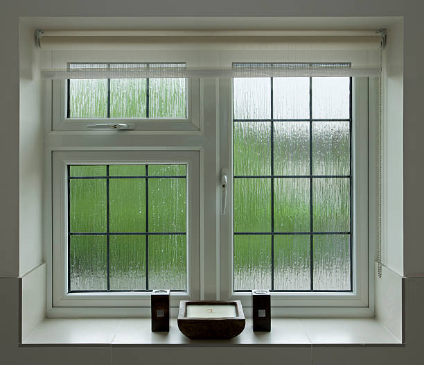 Zen bathroom window a beautifully finished leaded glass bathroom window with textured glass (opaque) overlooking a garden. On the window sill are three candles in a symmetrical arrangement providing a "Zen" feel to the image. window latch stock pictures, royalty-free photos & images