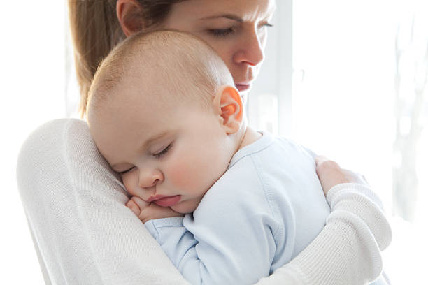 Mother With Her Baby Boy Sleeping In Her Arms
