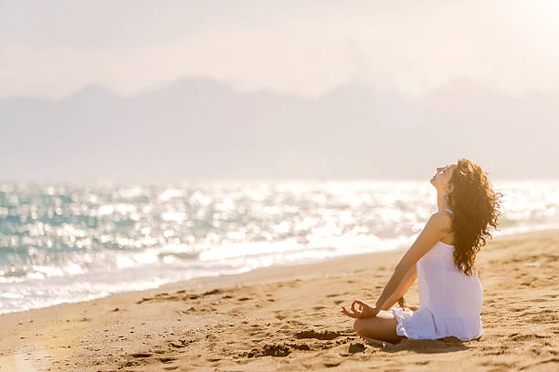 istock Young woman meditation on the beach 471332858