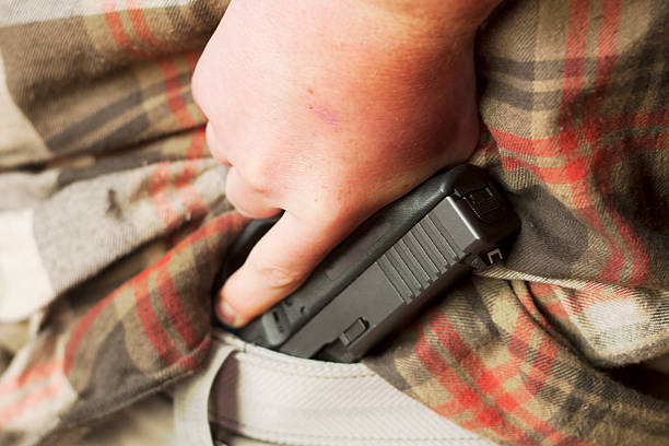 "arma da fuoco prelevato da nascosta in vita" - hiding carrying weapon handgun foto e immagini stock