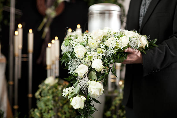 Flowers of grief at funeral and cemetery Religion, death and dolor  - funeral and cemetery; urn funeral funeral parlor photos stock pictures, royalty-free photos & images