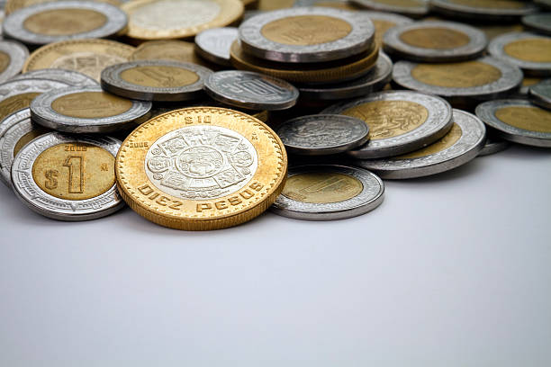 moneda de diez peso mexicano luz puntal entre otros pesos - spot lit fotografías e imágenes de stock