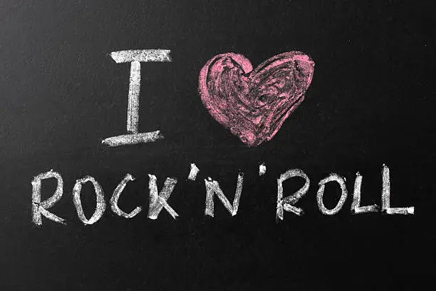 "I Love Rock'n'Roll" text written with chalk on a blackboard.