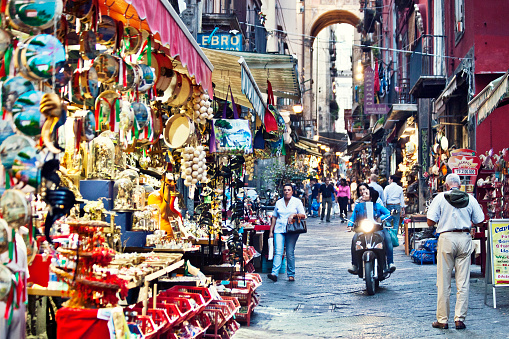 Naples, Italy - October 4, 2011: Tourist souvenir shops and cafes in historical old town of Naples.
