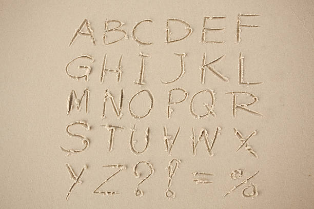 alfabet napisany w piasku na plaży. - sand text alphabet beach zdjęcia i obrazy z banku zdjęć