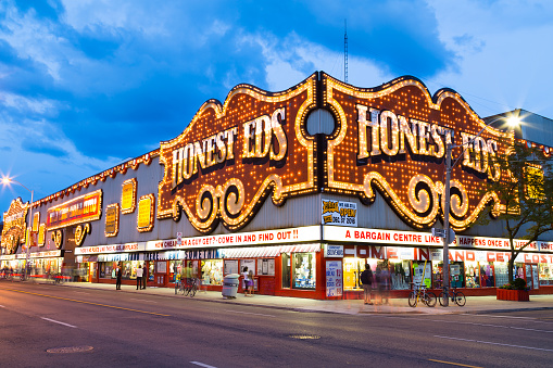 Toronto, Canada - July 30, 2014: The outside of Honest Eds at night in Toronto. People can be seen outside.