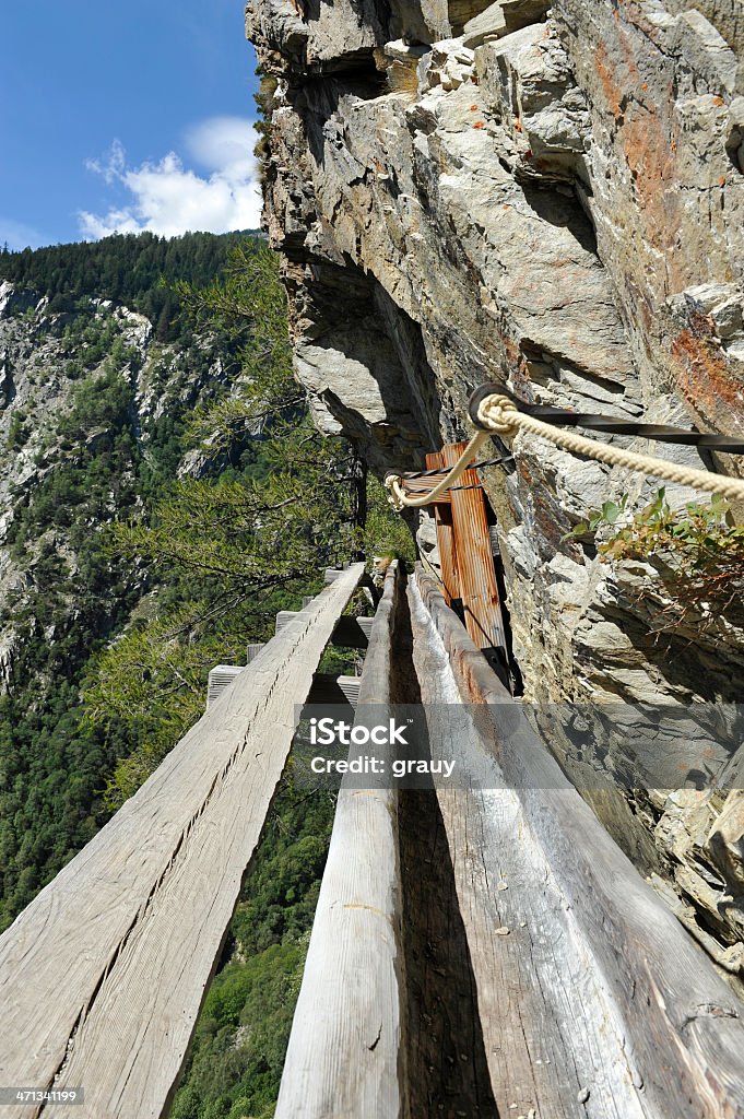 Artificial reach in the Swiss Alp - Valais Artificial reach in the Swiss Alp - Valais. this artificial reach called a "bisse" allow to transport the water along the cliffs from the glacier to the meadow in order to water them. Valais Canton Stock Photo