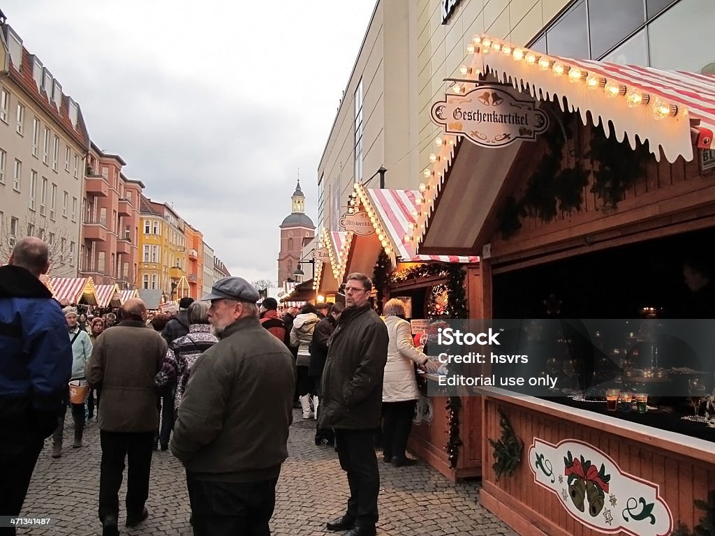 People visiting Christmas market in Berlin(Germany) Berlin, Germany - December 10, 2011: traditional Christmans market in Berlin district Spandau (Germany). People walking along the pedestrian zone with small snack bars and other kiosk for christmas gifts like on right side a candle and tea light store. In background Church of Spandau. . Berlin Stock Photo