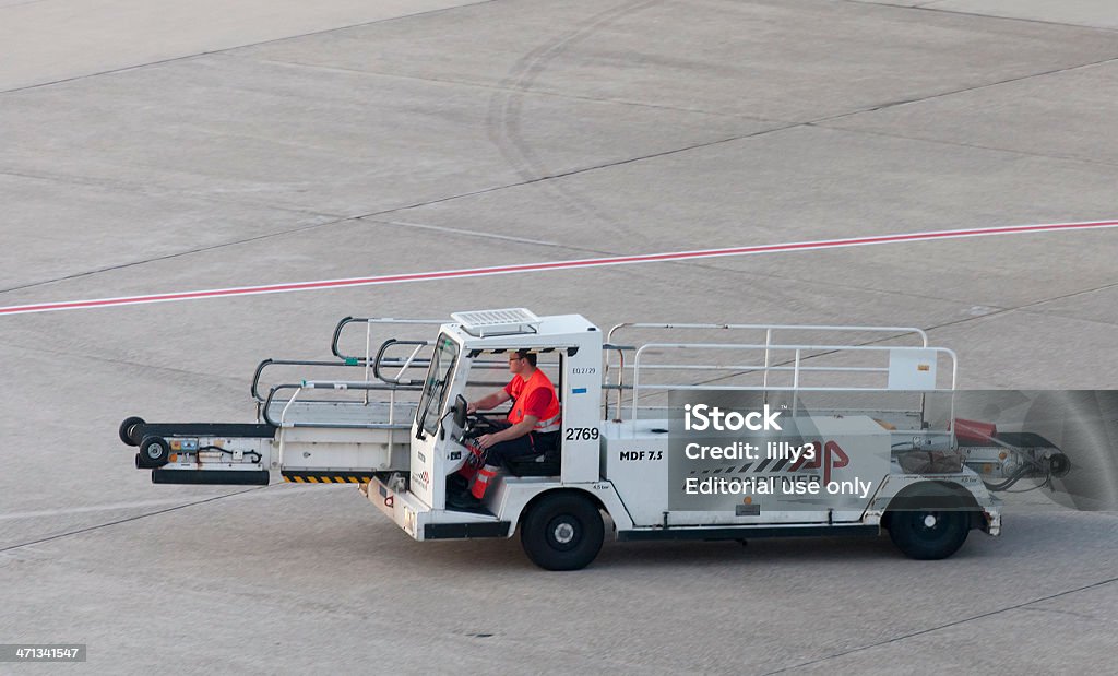 Técnico en tierra en automóvil del Aeropuerto de vehículo para la carga de equipaje - Foto de stock de Adulto libre de derechos