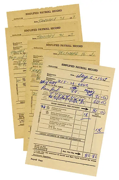 A group of American payroll record slips from the 1950s.