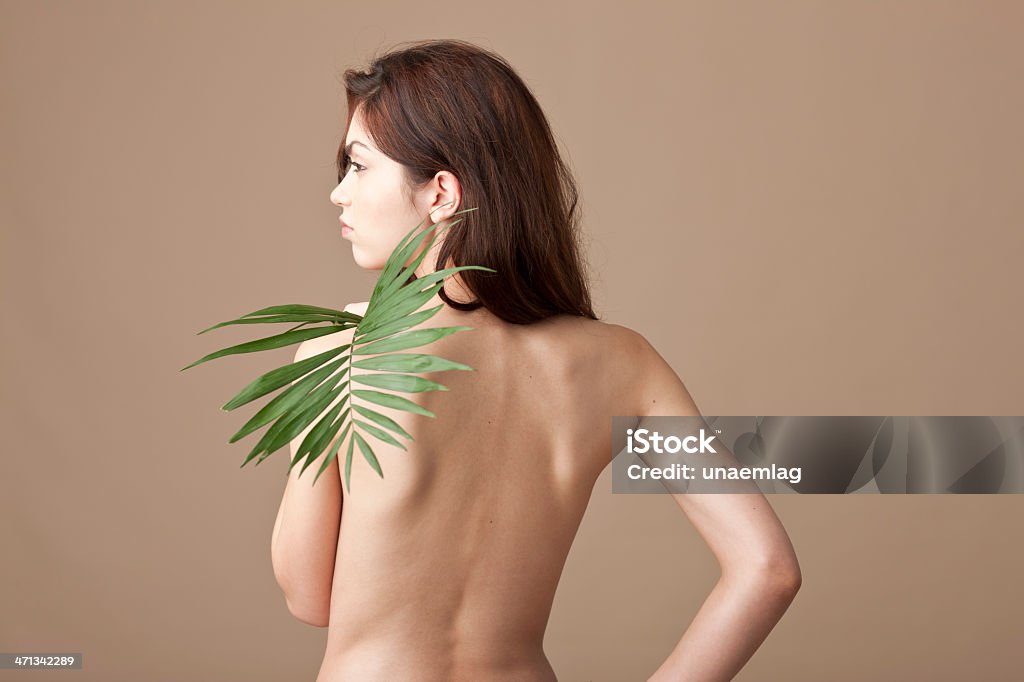 Женщина держит лист папоротника спине - Стоковые фото Белый роялти-фри