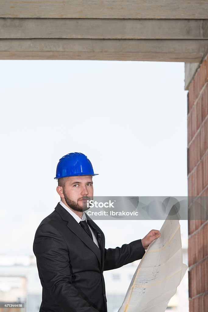 Portrait Of Happy Young Foreman With Hard Hat Portrait Of Construction Master With Blue Helmet And Blueprint In Hands 2015 Stock Photo