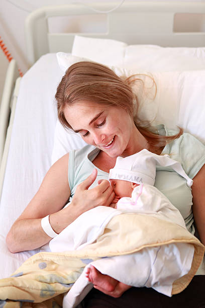 istock Young woman holding her sleeping 5 days old daughter 471345469