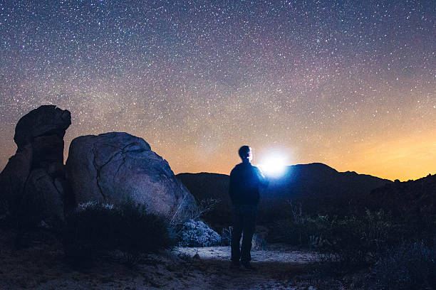 Man alone in the dessert with starry sky in the background