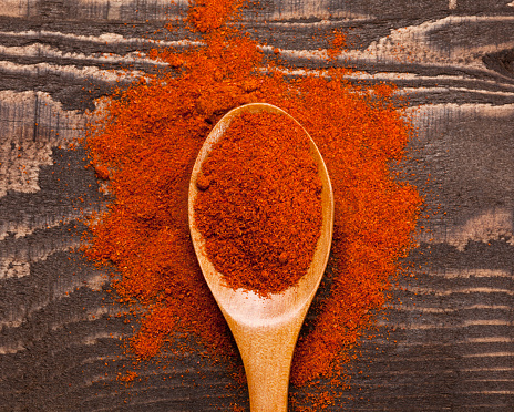 Close up of ground paprika in wooden spoon on wooden background; Adobe RGB color space; 