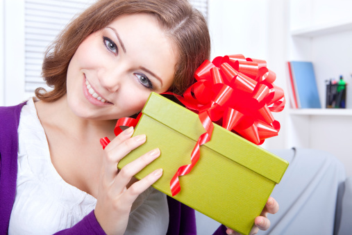 Beautiful young woman holding present