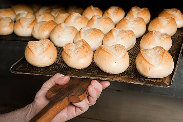 istock Person putting buns in oven 471346505