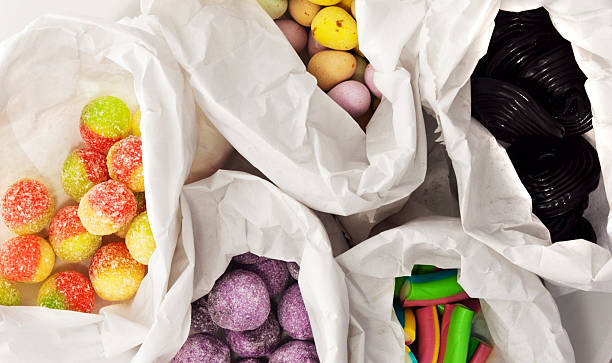 retro-süßigkeiten und bonbons in papier-taschen - unhealthy eating flash stock-fotos und bilder