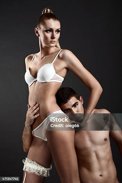 Donna In Lingerie Con Uomo Abbracciare - Fotografie stock e altre immagini di Abbigliamento intimo - Abbigliamento intimo, Abbracciare una persona, Abbracciarsi a letto