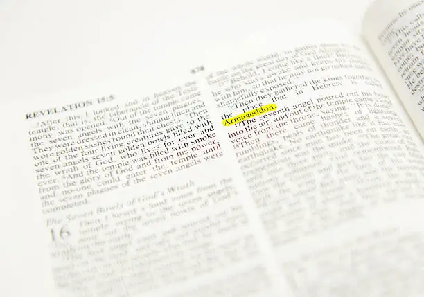 Bible opened in the book of Revelation, word "Armageddon" highlighted. Studio shot, converted from Nikon RAW.