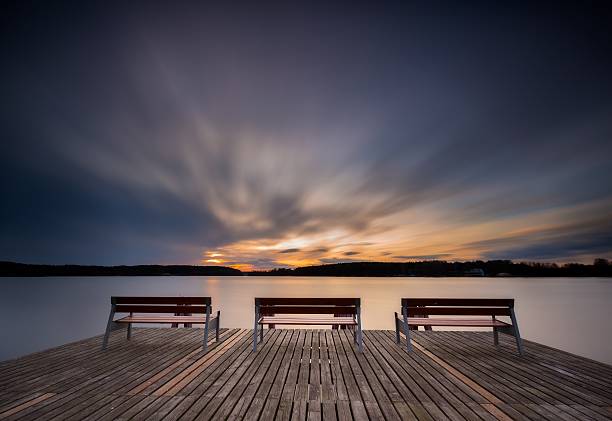 istock Beautiful long exposure lake with pier on foreground and bench. 471349646