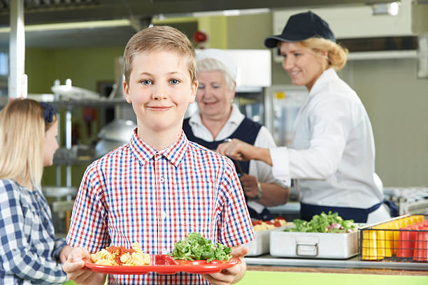 istock School aged boy posing with healthy lunch tray in cafeteria 471349658