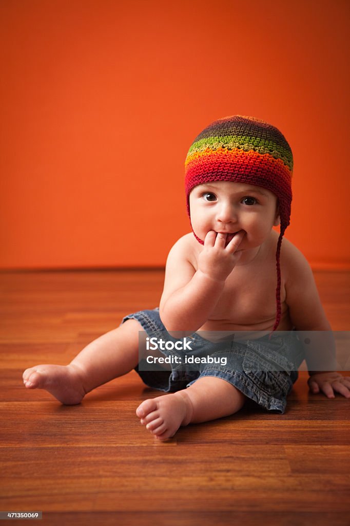 Image en couleur de l'heureux petit garçon assis sur sol en bois - Photo de 0-11 mois libre de droits