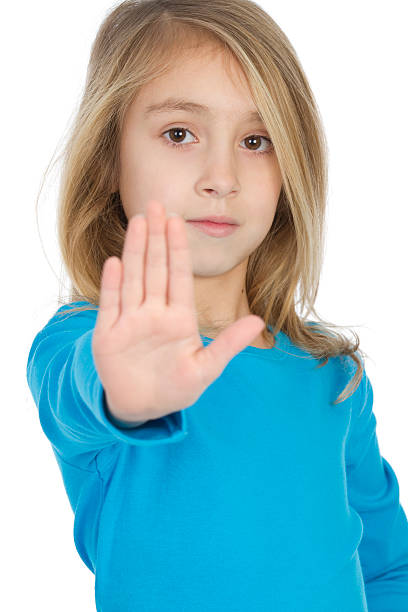 istock girl holding out hand to stop 471350289
