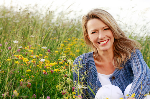 Happy middle aged woman in wild flower field