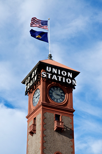 A low angle shot of the Union Station train depot Clock Tower with Union Station and Go by Train sign in Portland, Oregon.