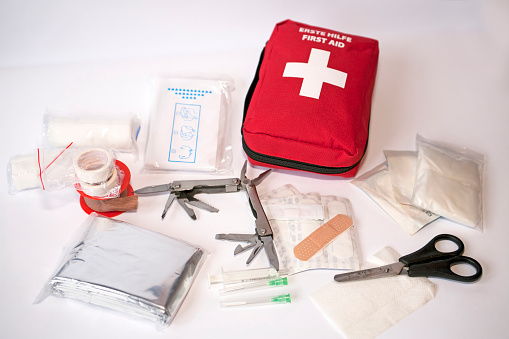 Open first aid kit with bandages, scissors, \