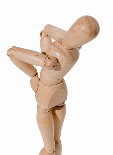 Wooden dummy gesturing back pain stock photo