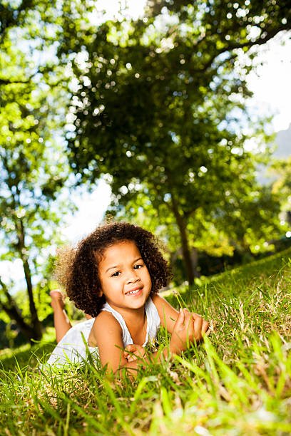 istock Smiling Little Girl Relaxing On Grass 471356931