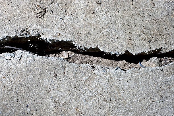 istock cracked road concrete close up 471357034