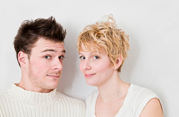 High angle shot of an affectionate young couple lying down together on the wooden floor of their art studio