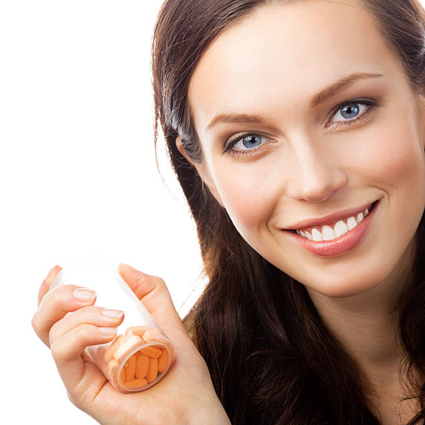 istock Woman showing bottle with pills, isolated 471359225