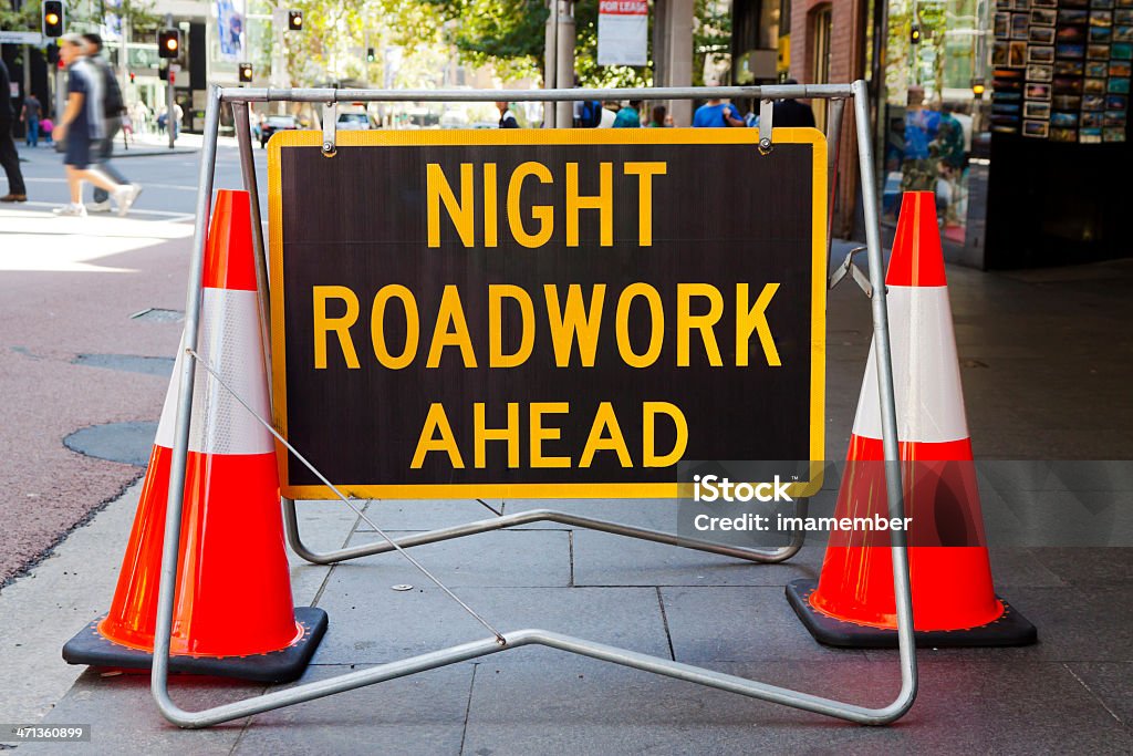 Sinal de estrada à noite que as obras ahed'e dois cones vermelho - Foto de stock de Construção de Estrada royalty-free