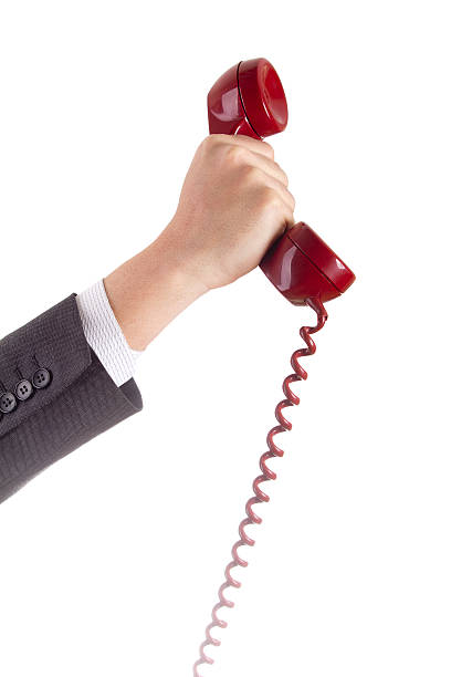 istock Retro red telephone hook and cord in the hand 471362035