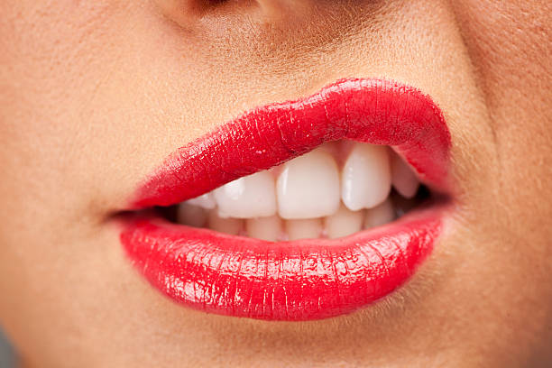 istock Women raising her lip with bright red lipstick 471364004