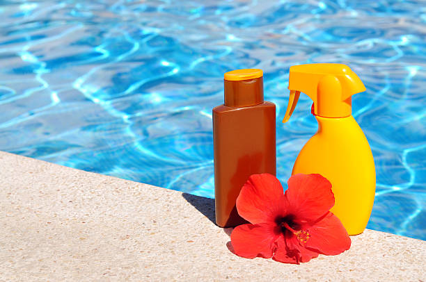 istock Hibiscus flower and suntan lotion at the pool 471364393