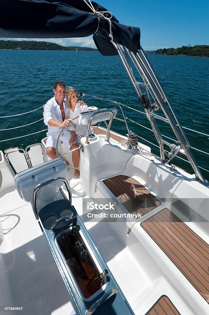 Casal feliz dirigindo um veleiro - Foto de stock de Homens royalty-free
